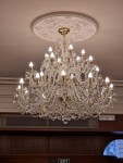A golden version of the chandelier modified for a low ceiling in a hotel reception