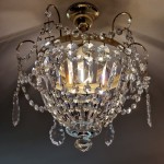 The light from the basket chandelier passes through the crystal prisms