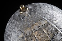 Detail of lace carving on the glass shade of a decorative lamp.