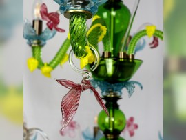 Glass butterflies on the green glass arms of the chandelier