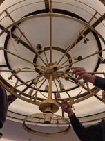 Installation of crystal pendants and chain on the brass structure of the chandelier