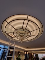 Chandelier on a glass suspended ceiling made of flat glass.