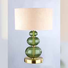 A discreet table lamp made of dark green glass in the color of a fallen star (Moldavite).