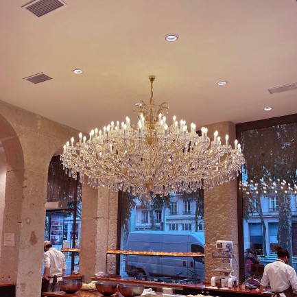 A large wide chandelier of Maria Theresa on the ceiling of the confectionery