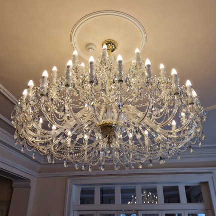 The large crystal chandelier on the ceiling of the hotel restaurant